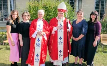 El P. John Morrill y el obispo de East Anglia (al centro) con las cuatro hijos del nuevo sacerdote a los costados.