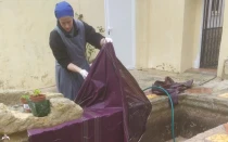 Una religiosa del Instituto del Verbo Encarnado lava una casulla estropeada por el barro en España.