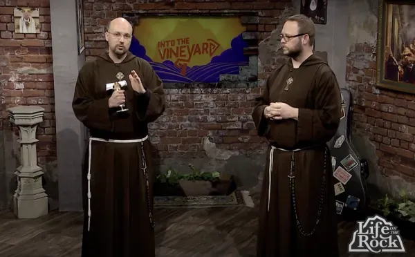 Father John Paul Mary blesses a relic of St. Maximilian Kolbe's beard on the set of 