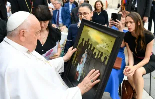 El Papa Francisco con un cuadro que representa el sufrimiento de migrantes este 19 de junio Crédito: Vatican Media