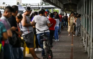 Los migrantes, en su mayoría de Centroamérica, esperan en fila para cruzar la frontera en el Puente Internacional Gateway hacia los Estados Unidos, desde Matamoros, México, a Brownsville, Texas, el 4 de junio de 2024. Crédito: CHANDAN KHANNA/AFP vía Getty Images.