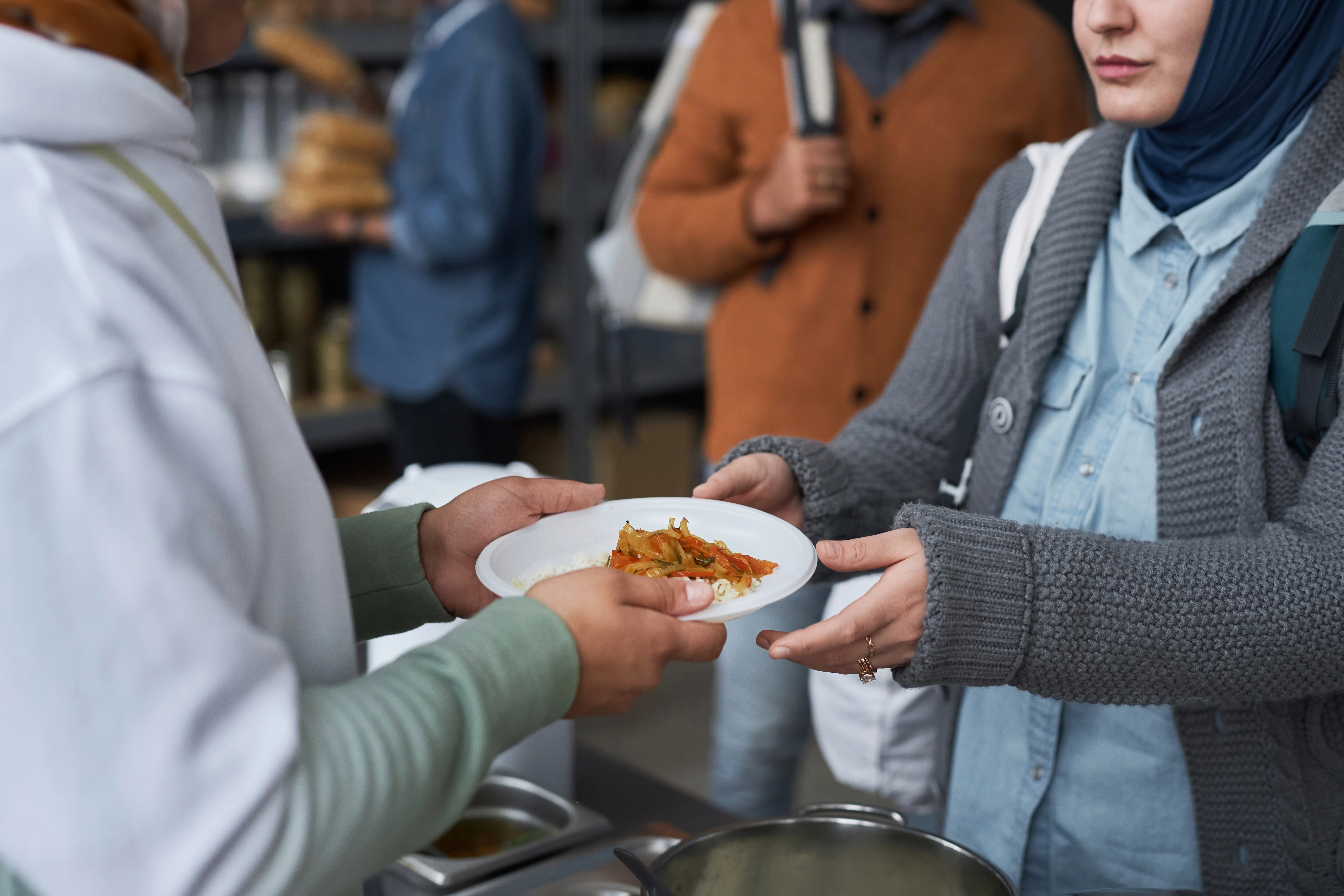 Voluntarios otorgando comidas calientes gratuitas a refugiados.?w=200&h=150