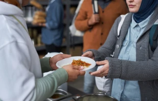 Voluntarios otorgando comidas calientes gratuitas a refugiados. Crédito: Shutterstock