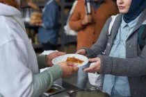Voluntarios otorgando comidas calientes gratuitas a refugiados.