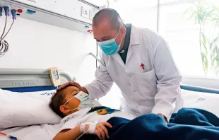 El sacerdote camiliano John Jairo Loaiza visita a un niño en un hospital de Bogotá. Crédito: Eduardo Berdejo (ACI).