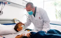 El sacerdote camiliano John Jairo Loaiza visita a un niño en un hospital de Bogotá.