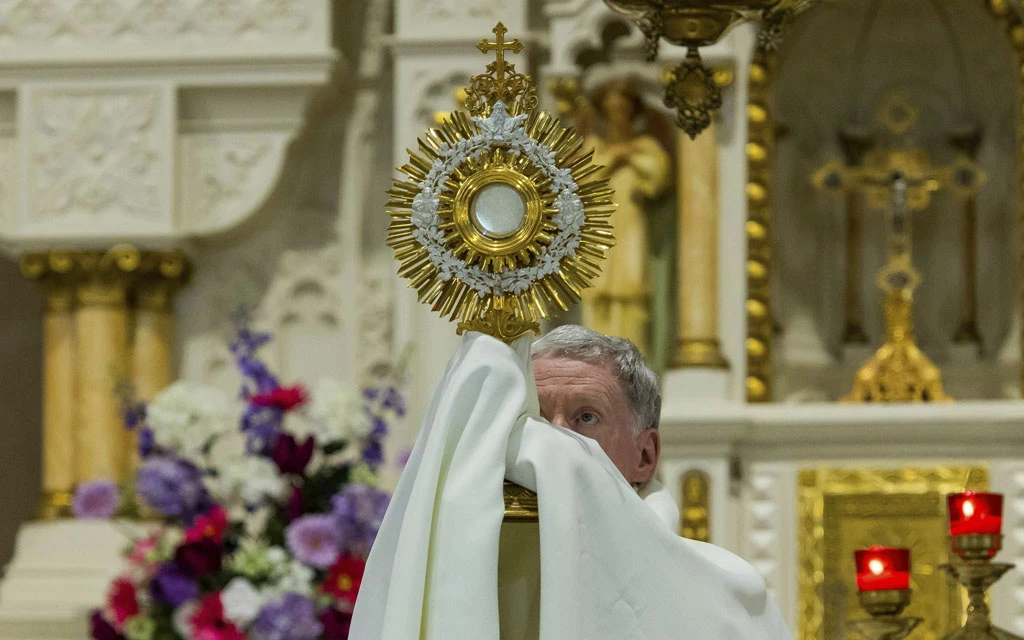 Un sacerdote sostiene una custodia con el Santísimo Sacramento.?w=200&h=150