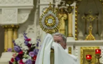 Un sacerdote sostiene una custodia con el Santísimo Sacramento.