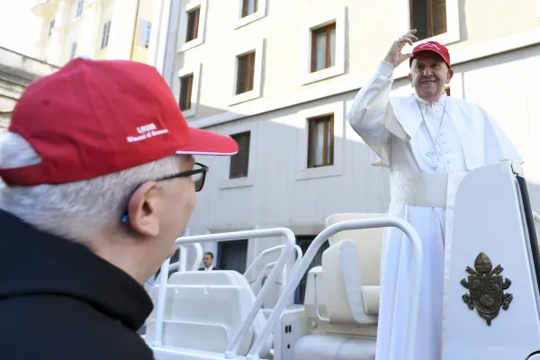 Pope Francis puts on a cap given to him by a group of Italian children during a General Audience. Credit: Vatican Media