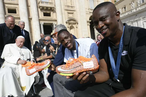 Letsile Tebogo shows his sneakers before greeting Pope Francis. Credit: Vatican Media