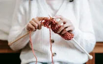 Imagen referencial de una mujer tejiendo ropa.