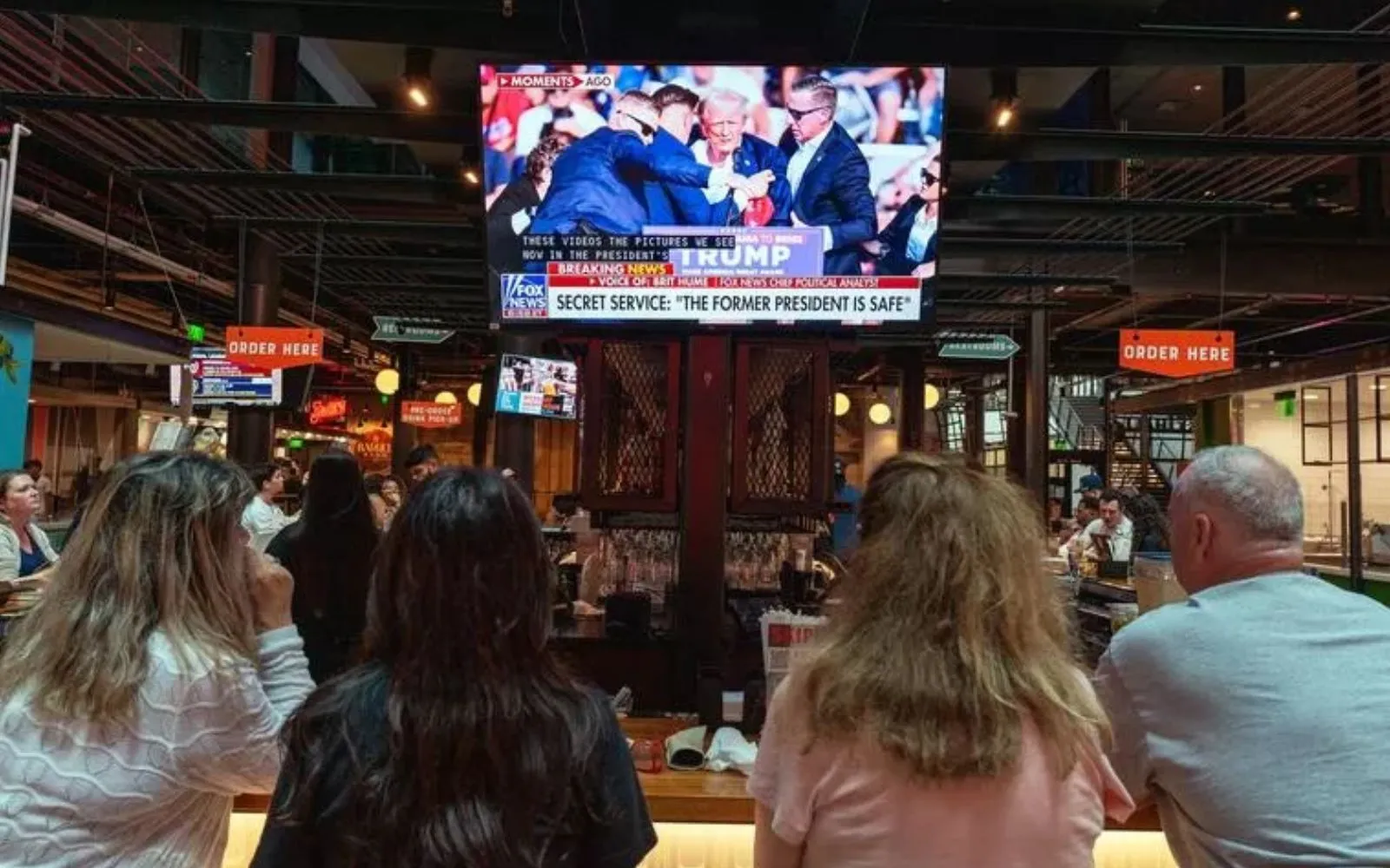 Varias personas miran las noticias de televisión el 13 de julio, en un bar de Milwaukee, que muestra imágenes de un mitin de campaña del expresidente de Estados Unidos Donald Trump en Butler, Pensilvania, donde fue blanco del atentado.?w=200&h=150