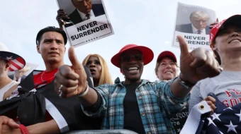 Simpatizantes del expresidente Donald Trump observan mientras éste realiza un mitin en el distrito históricamente demócrata del sur del Bronx el 23 de mayo de 2024, en la ciudad de Nueva York (Estados Unidos).