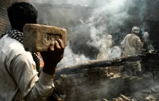 Una turba de musulmanes lanzan ladrillos a una casa cristiana después de incendiarla, en Lahore, Pakistán, el sábado 9 de marzo de 2013. Crédito: Murtaza.Ali - Shutterstock