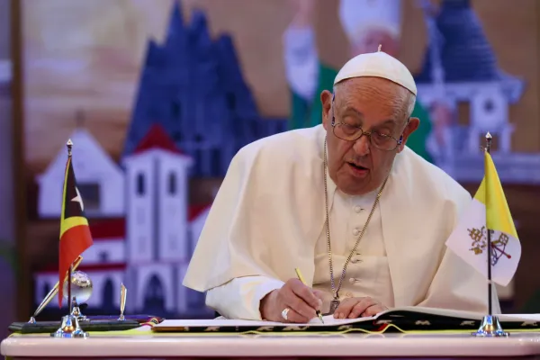 Pope Francis signs the book of honor. Credit: Daniel Ibáñez/EWTN News