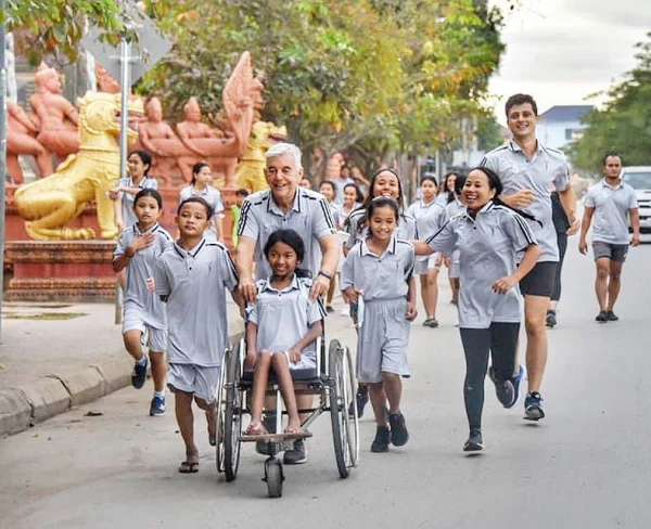 Kike Figaredo pushes a girl in a wheelchair with other children. Credit: Courtesy