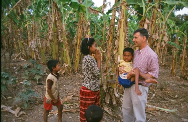 Photograph of Father Figaredo with a disabled child in his arms. Credit: Courtesy