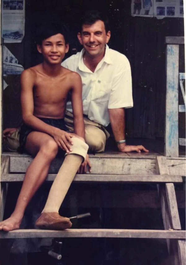 Imagen de los primeros años del P. Kike en Camboya con uno de los niños mutilados. Crédito: cortesía